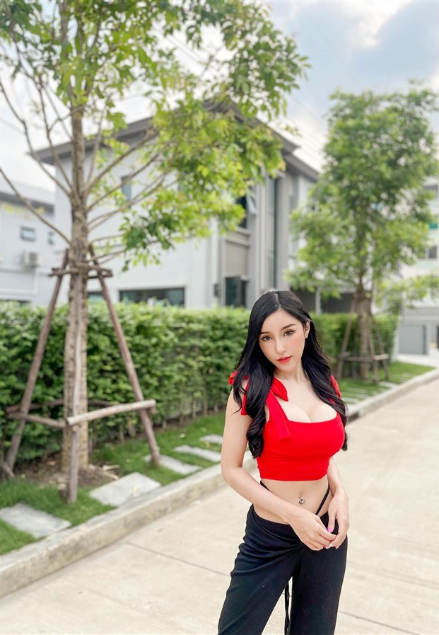 ครอปท็อปแดงกับกางเกงดำบนถนนในหมู่บ้าน