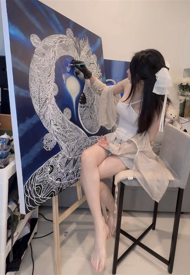 นั่งบนสตูลข้างภาพวาดฝีมือตัวเอง