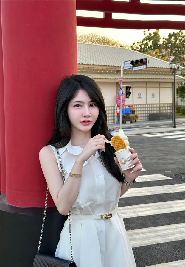 เดรสแขนกุดสีขาวถือเครปเย็นหน้าป้ายสถานีรถไฟสไตล์ญี่ปุ่น