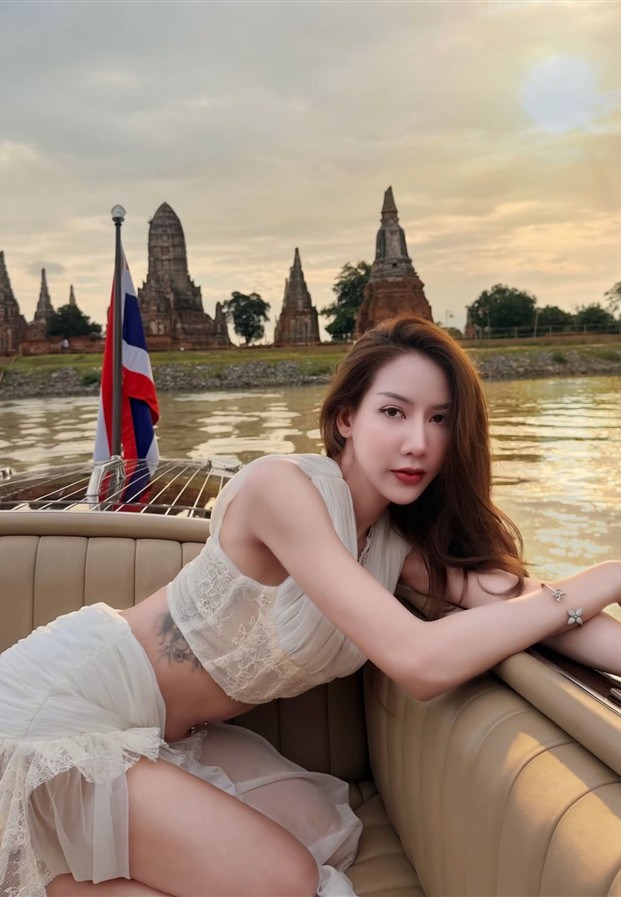 ชุดลูกไม้สีขาวเอนกายบนเบาะเรือริมแม่น้ำยามเย็น