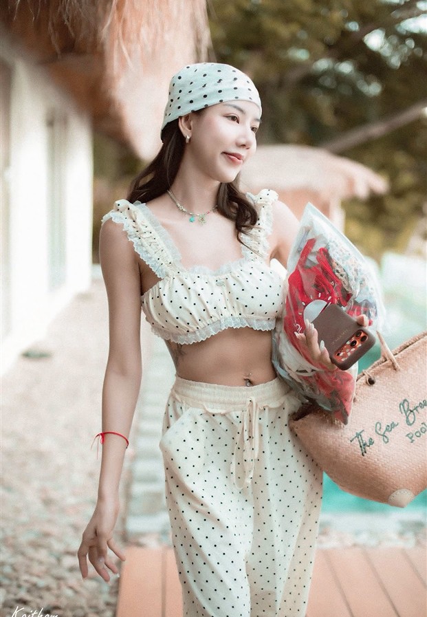 ชุดเซตลายจุดสีขาวโพกผ้าคาดผมถือกระเป๋าสานกลางแจ้ง
